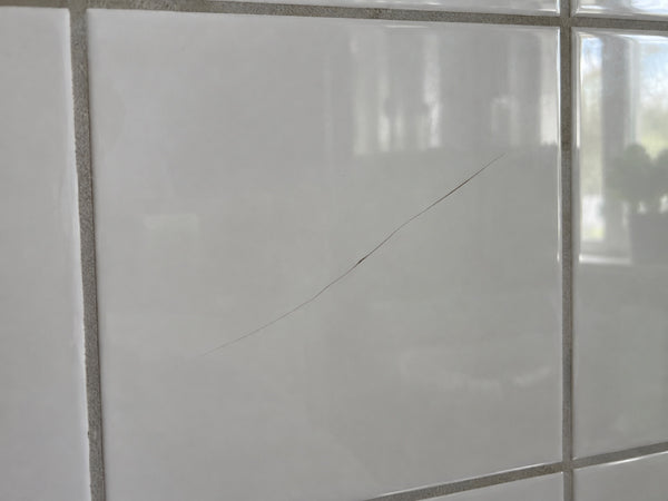 Haarscheur in een witte badkamertegel