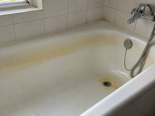 Wit bad met gele verkleuring langs de waterlijn