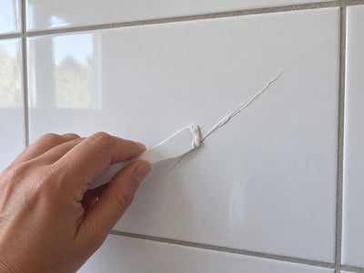 Spatel strijkt reparatiepasta in de scheur